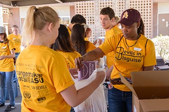 ASU students stuffing lunch bags at a service event